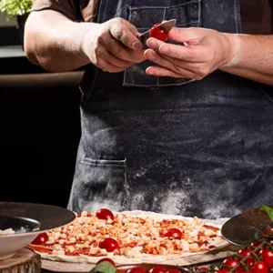 El chef Florin cortando cherry para pizza artesana en restaurante italiano Fiori D'Italia